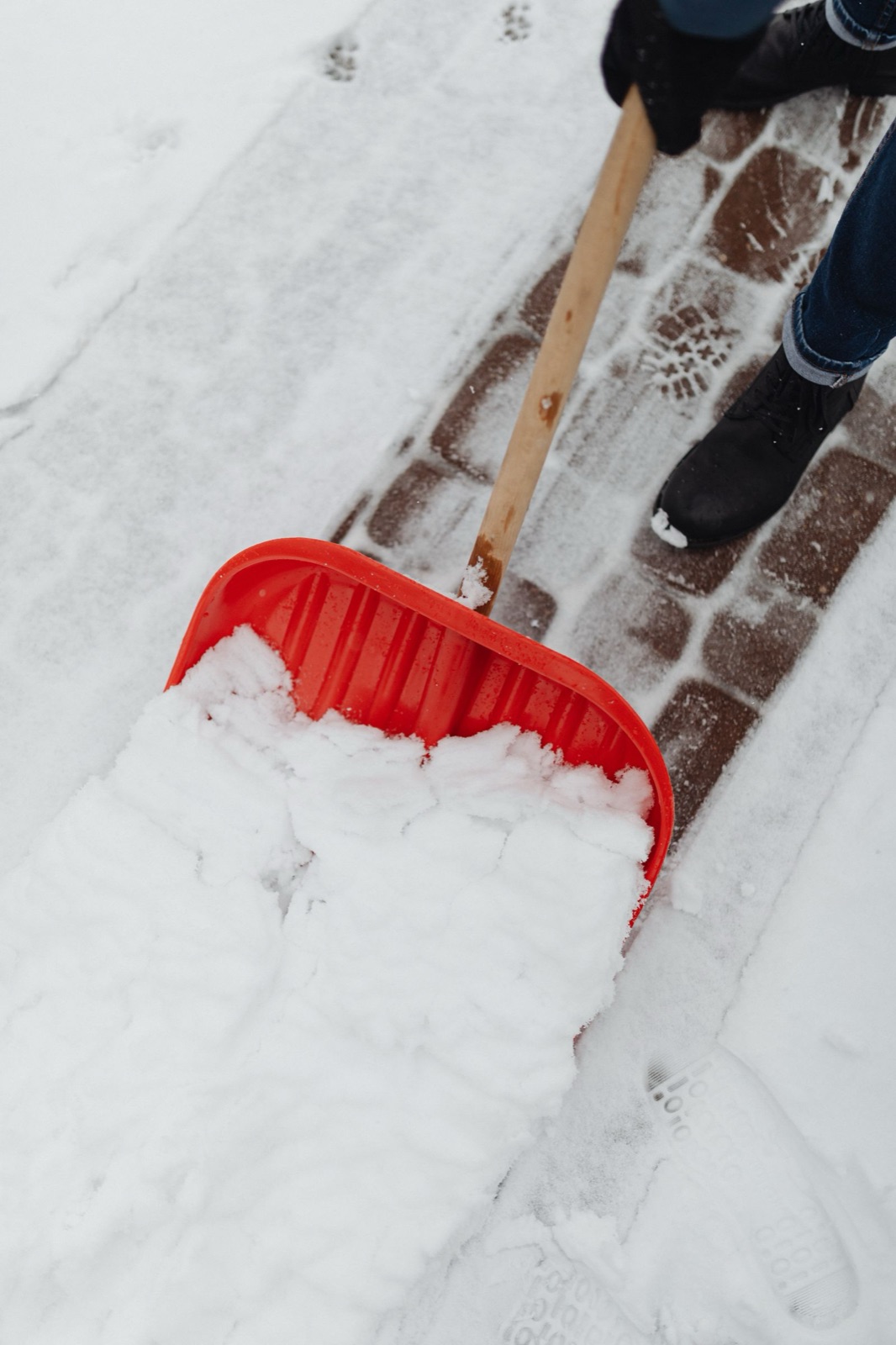 Geräumter und gestreuter Gehweg vor einem Wohngebäude im Winter